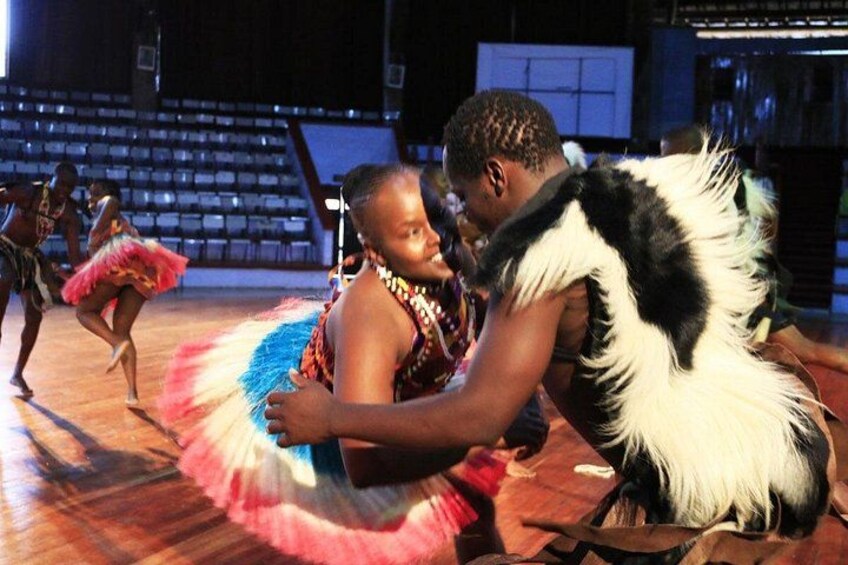 A dance performance with dancers in colorful costumes on a stage. 4