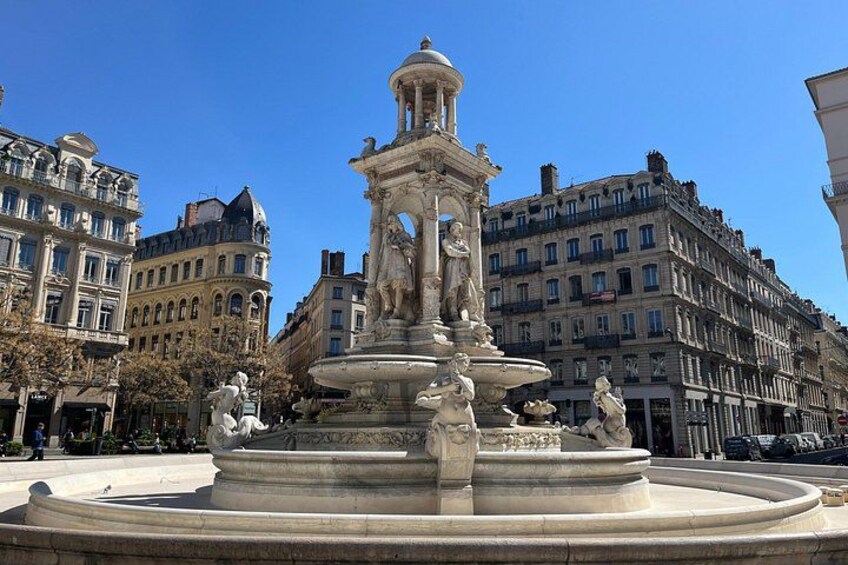A classical fountain with statues in a city square surrounded by historic buildings. 4