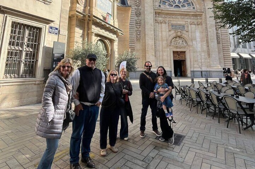 A group of people standing in front of a historic building with ornate architecture. 3