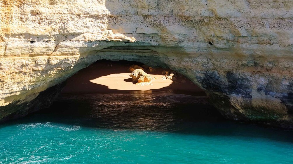 A coastal cave entrance with turquoise water. 4