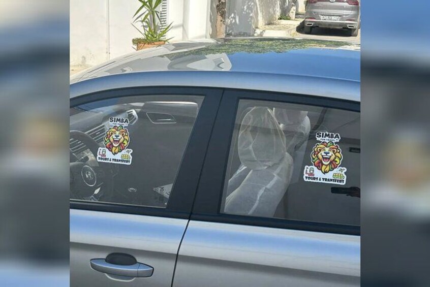 A car with stickers on the windows and a logo on the hood. 2