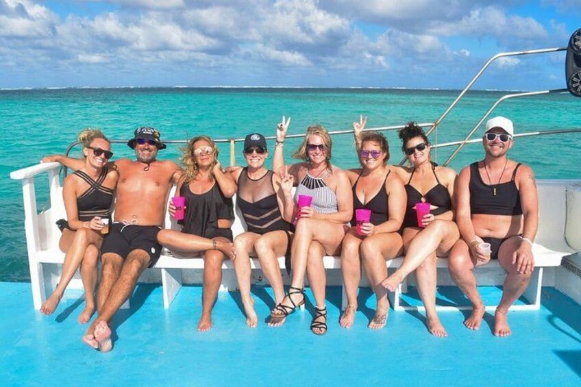 Un grupo de personas en un barco con aguas turquesas al fondo. 4