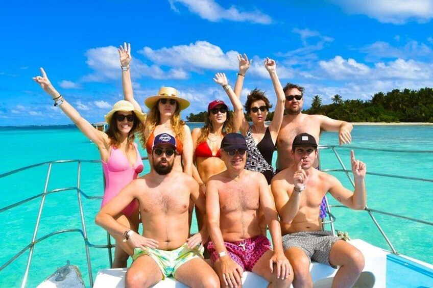 Un grupo de personas en un bote en aguas turquesas bajo un cielo despejado. 3