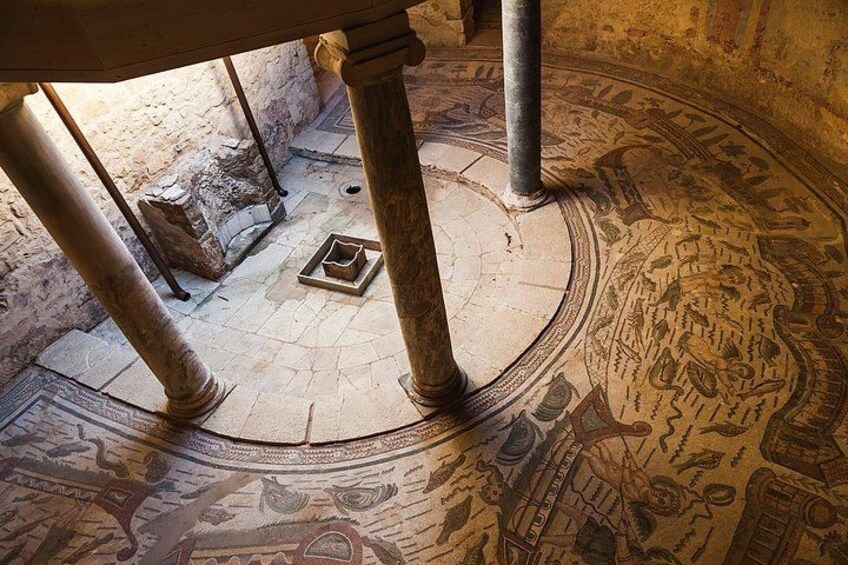 Un piso de mosaico antiguo con diseños intrincados y columnas. 5