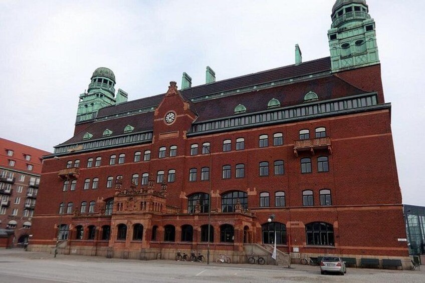 A large red brick building with a clock tower and a dome. 4