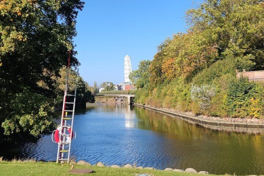 A calm river with a bridge, a ladder, and a building in the background. 3