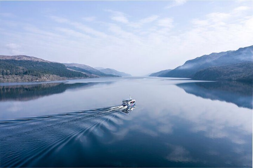 A boat on a calm lake with mountains in the background. 4