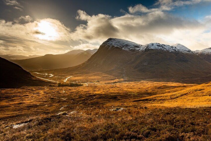 A mountainous landscape with a valley, snow-capped peaks, and a river. 5