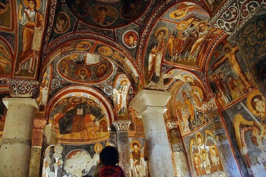 An interior of a church with detailed frescoes and arches. 1