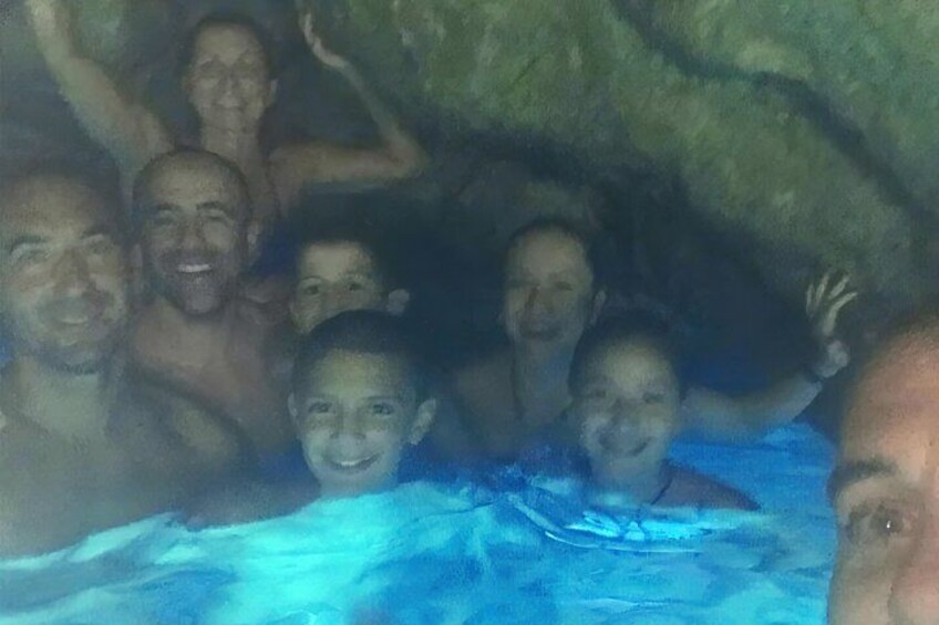 Eine Gruppe von Menschen in einem Schwimmbecken vor einer felsigen Kulisse. 4