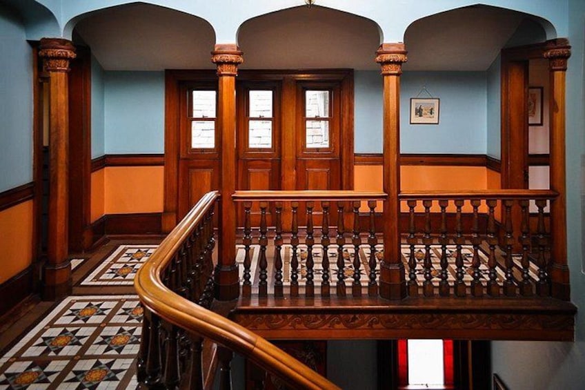 Un escalier en bois, doté de balustres décorées et d’un sol à motifs. 3