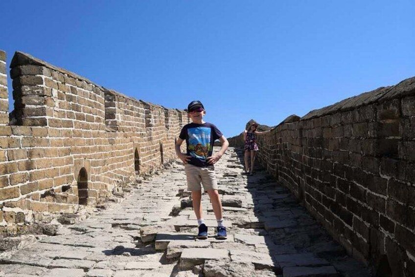Une personne se tient sur un chemin de pierre situé entre les différentes sections de la Grande Muraille de Chine. 4