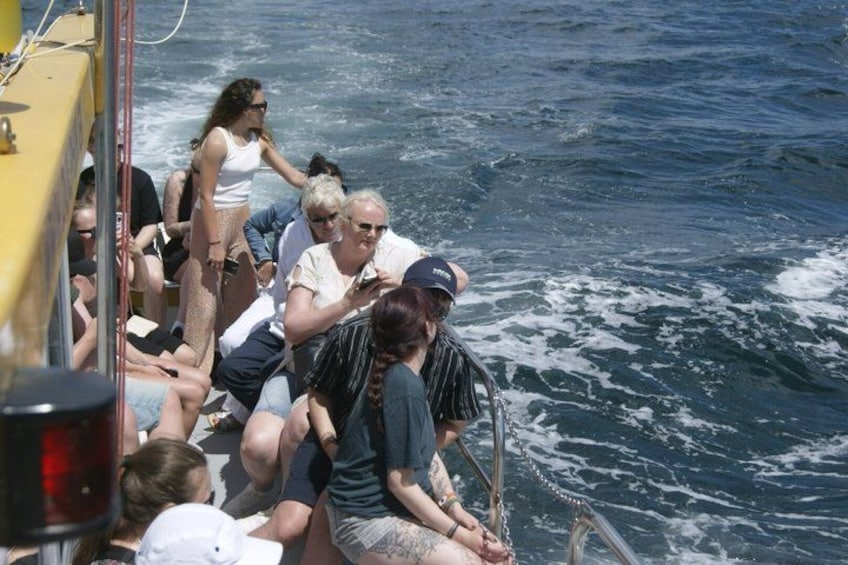 Un grupo de personas en un barco con el océano de fondo. 4