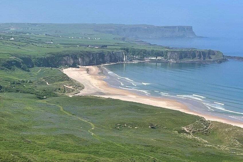 Un paysage côtier avec des falaises, une plage et un sentier. 1