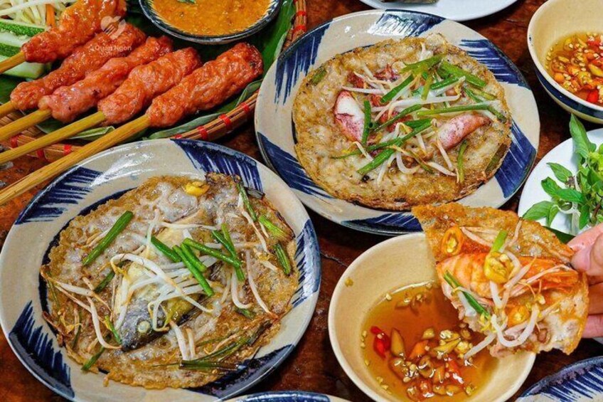 A variety of Southeast Asian dishes, including grilled meats, fried rice, and a bowl of soup. 2