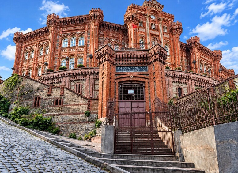 A grand, red-brick building with ornate architectural details, including arched windows and a central clock tower. 4