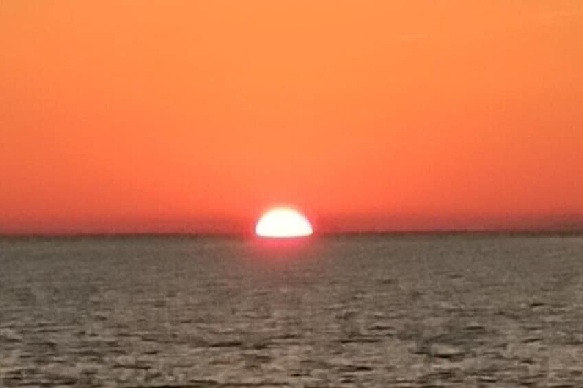 A sunset over a calm sea with a clear horizon. 5