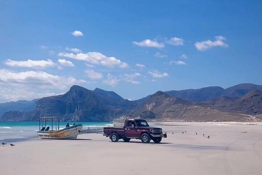 A beach with a truck and a boat. 3