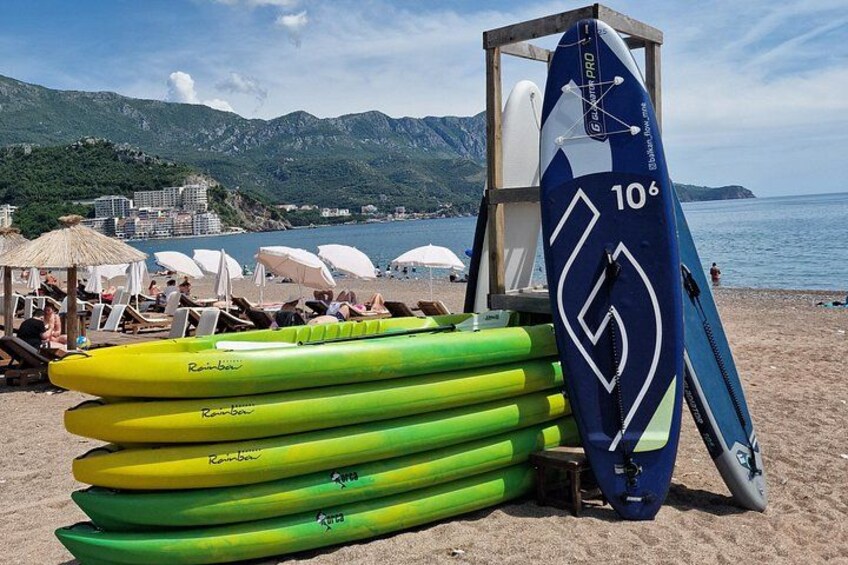 A beach with kayaks, umbrellas, and a lifeguard tower. 2