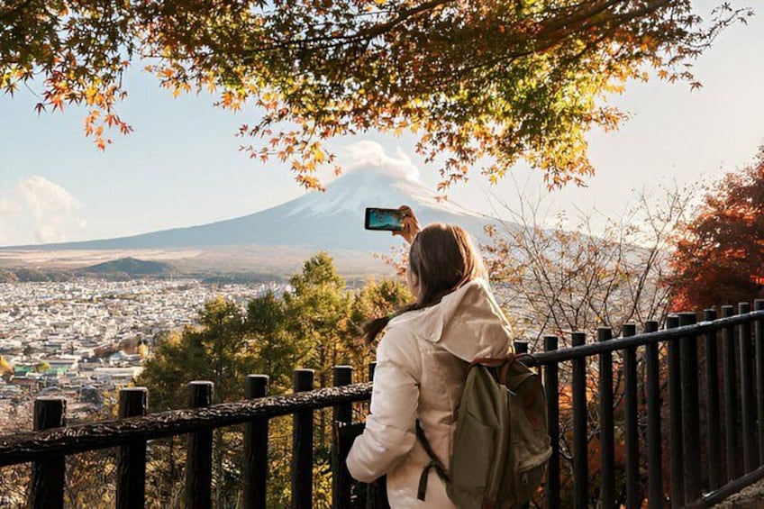 Une personne prend une photo d’une montagne, avec une ville en arrière-plan. 2