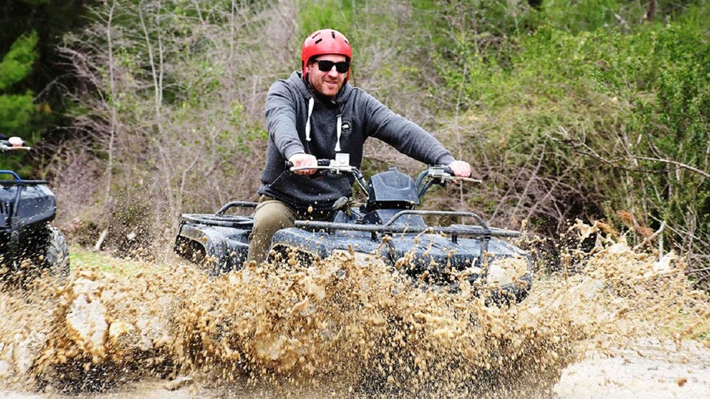 En person kører på en ATV gennem et mudret område. 3
