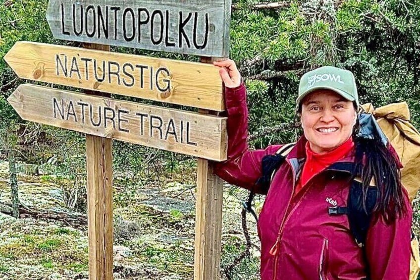 A person holding a sign for the Luontopolku Nature Trail. 2