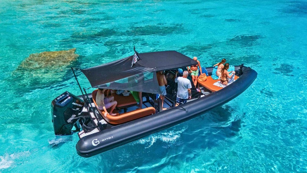 Ein Boot mit Personen auf ruhigem, blauem Wasser. 4