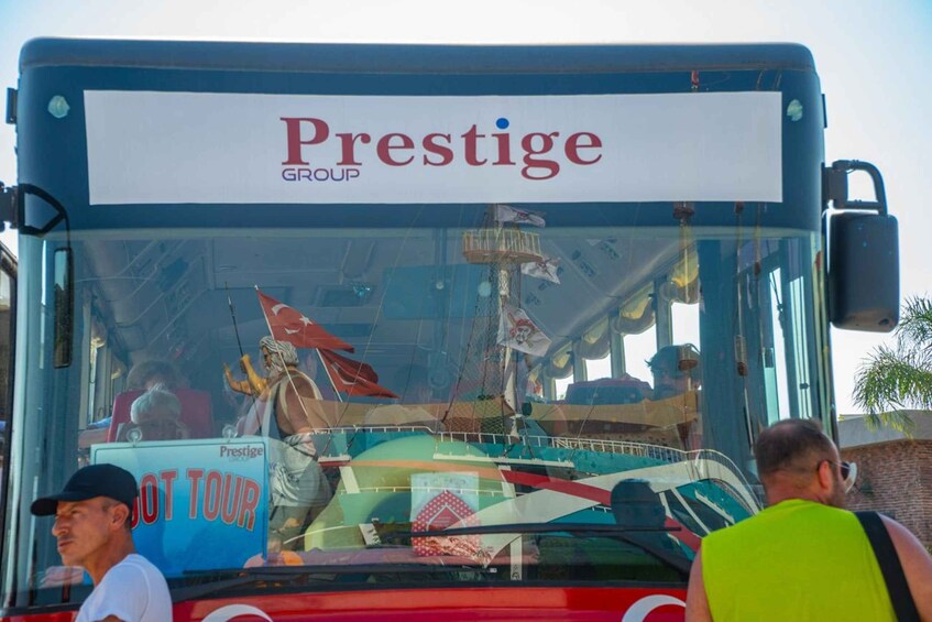 Bussissa oli kyltit, joissa luki ”Prestige Group” ja ”HOT TOUR”, ja siinä oli myös mies, jolla oli päällään keltainen liivi. 2