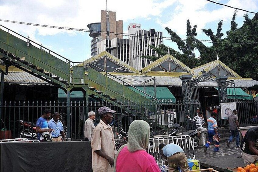 A street scene with a stage, people, and a building with a green roof. 3
