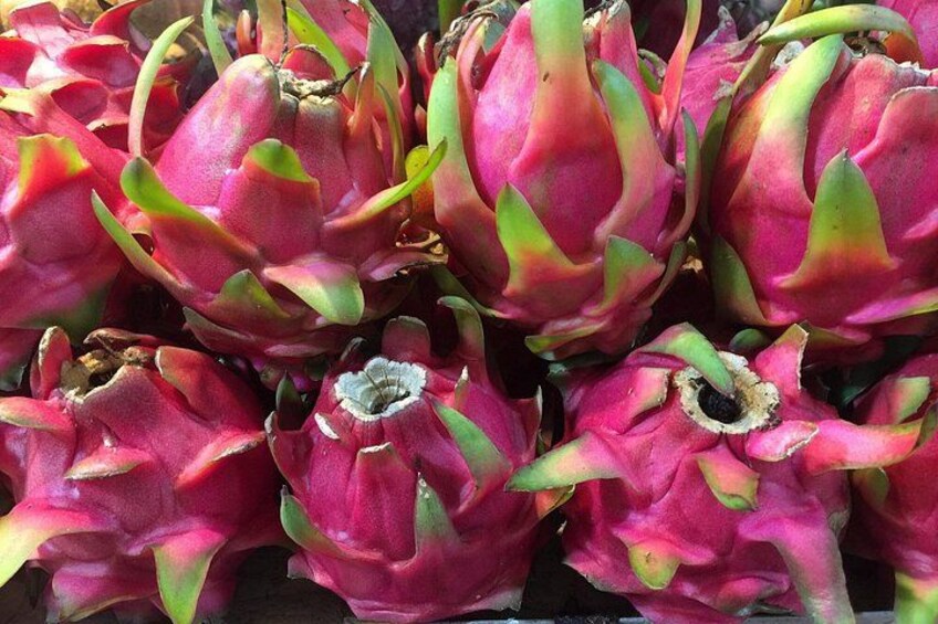 A cluster of dragon fruit with pink and green hues. 4