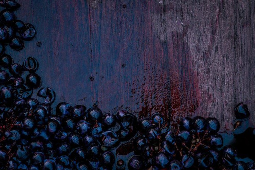 Una superficie de madera con racimos de uvas. 1