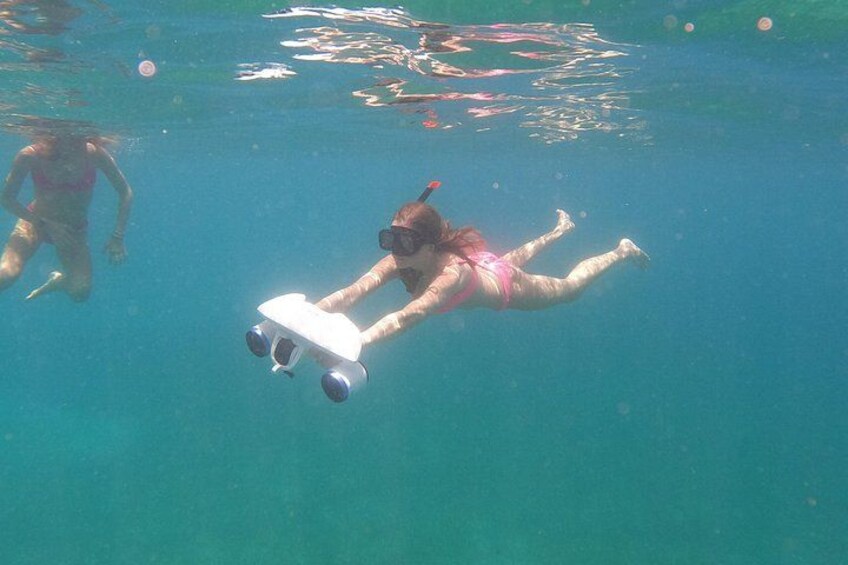 Una persona nadando bajo el agua con un snorkel y aletas. 3