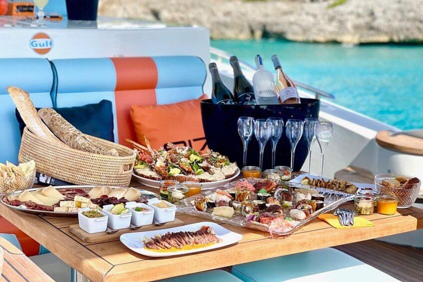 Un bote con un montaje para comer junto al agua, que incluye comida, bebidas y una cesta de mimbre. 5