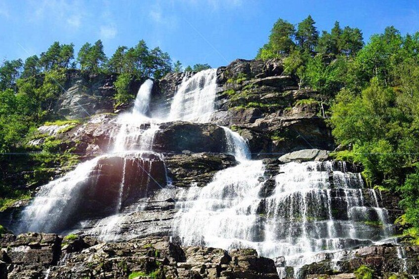 A multi-tiered waterfall surrounded by dense forest. 2