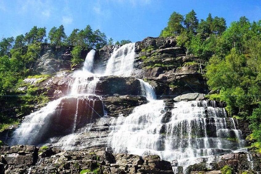 A multi-tiered waterfall surrounded by dense forest. 2