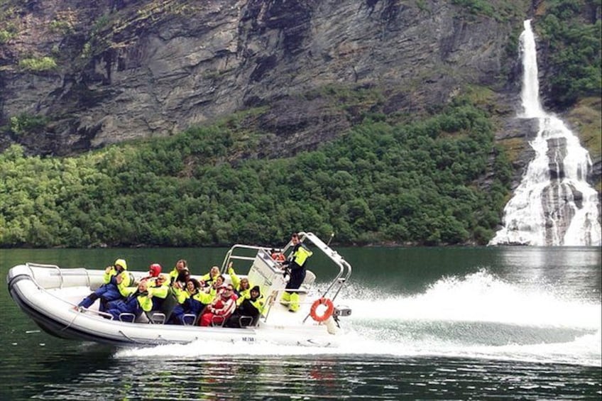 Un grupo de personas en un bote cerca de una cascada. 1