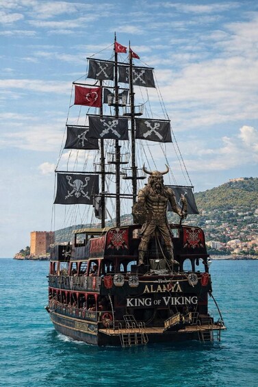 A pirate-themed ship named 'King of Viking' with a figurehead, sailing in a harbor with a castle in the background. 3