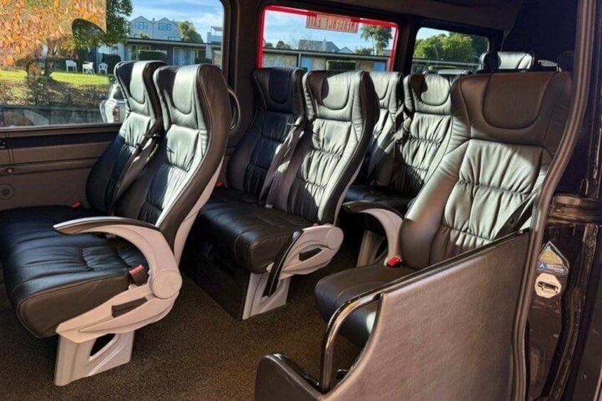 Ein Fahrzeuginnenraum mit Ledersitzen und einem Getränkehalter. 3