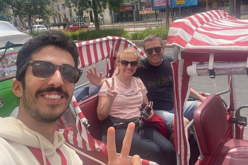 A vintage car with red and white stripes, a person making a peace sign, and another person in a pink shirt. 4
