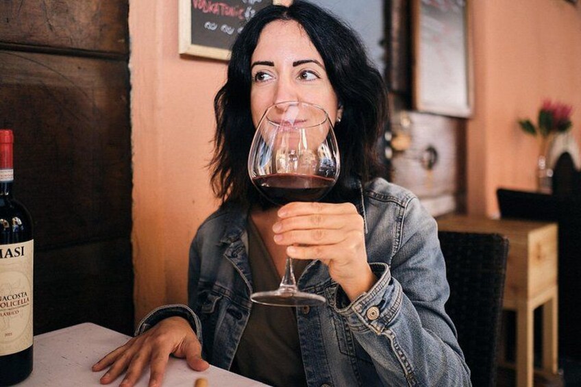 Una persona sentada a una mesa con una botella de vino y una copa. 2