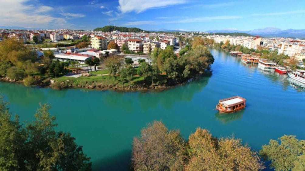 A river with a boat, a cityscape, and a hill in the background. 5
