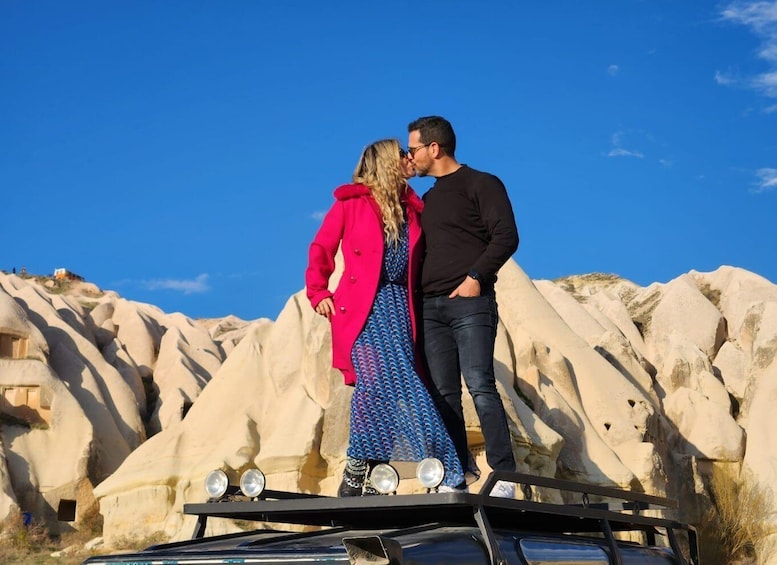 Un couple se tient debout sur un véhicule, dans un paysage rocheux. 2