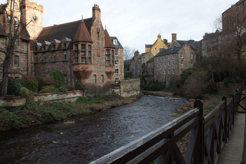 A river with a bridge, historic buildings, and a clock tower. 1