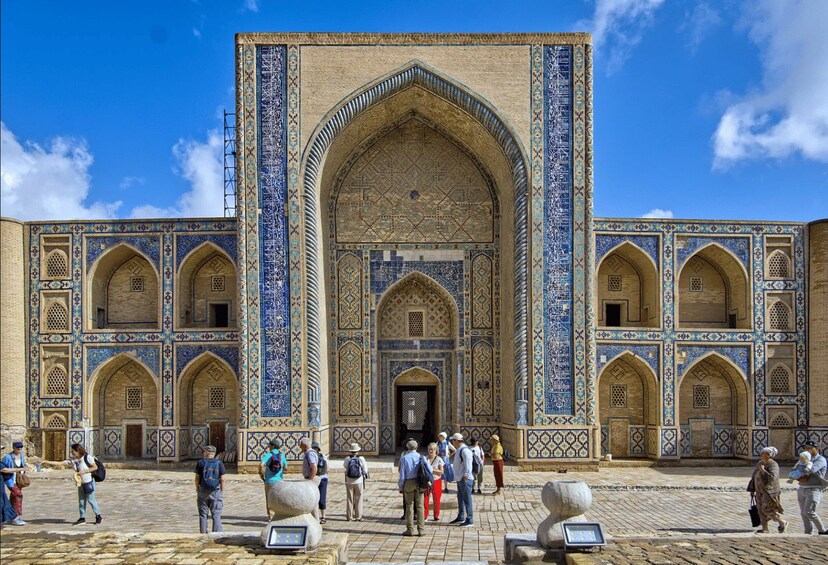 A historic building with intricate blue and white tile work, arched doorways, and a central entrance. 3