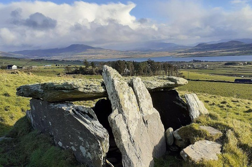 A stone circle with a grassy field and distant mountains. 3