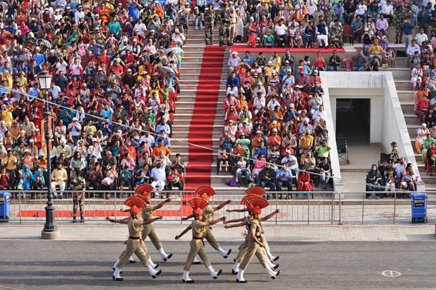 A group of performers in golden costumes with red headdresses walking on a street. 3
