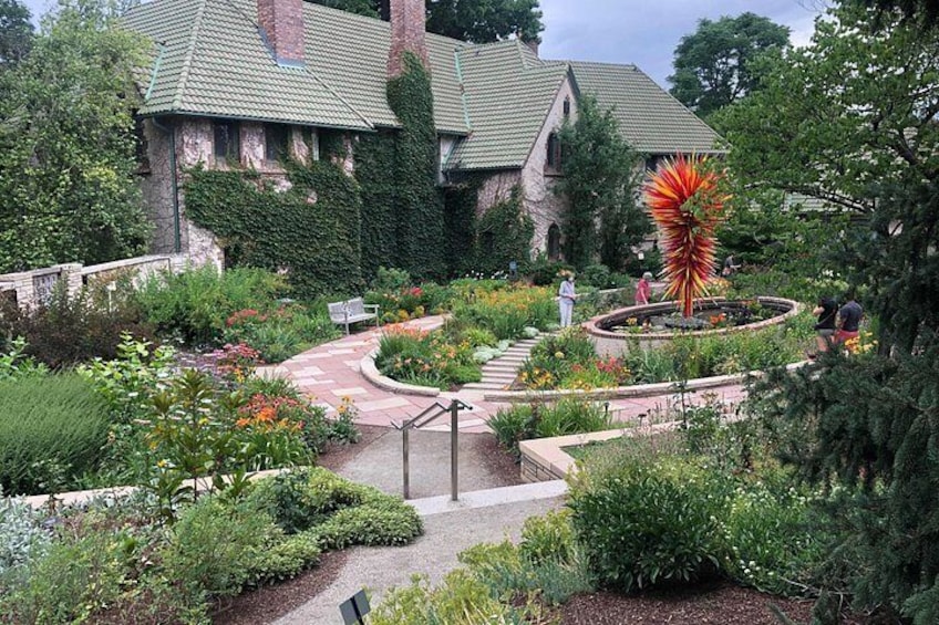 A garden with a winding path, a large spiral sculpture, and a building with a green roof. 2