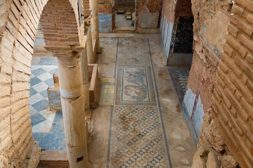 An ancient architectural structure with brick columns and patterned flooring. 2