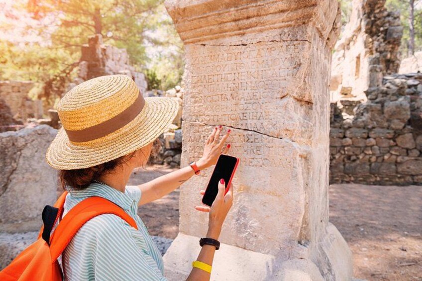 A person taking a photo of ancient stone inscriptions with a smartphone. 3