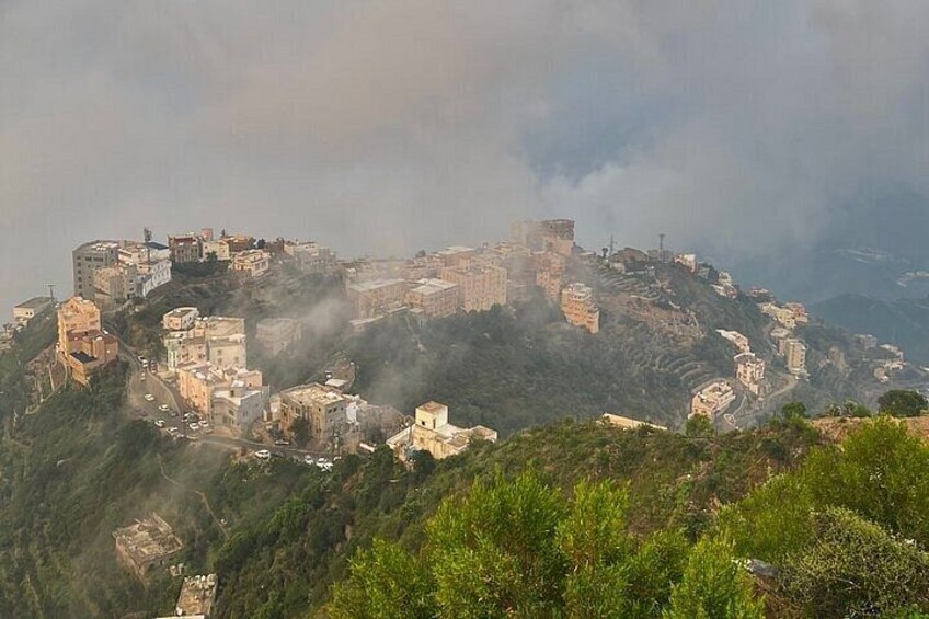 A historic walled city on a hill with ancient buildings and a fortress. 3
